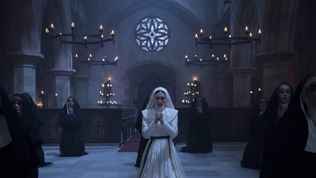 Taissa Farmiga as Sister Irene in "The Nun" prays with other nuns in a chapel.